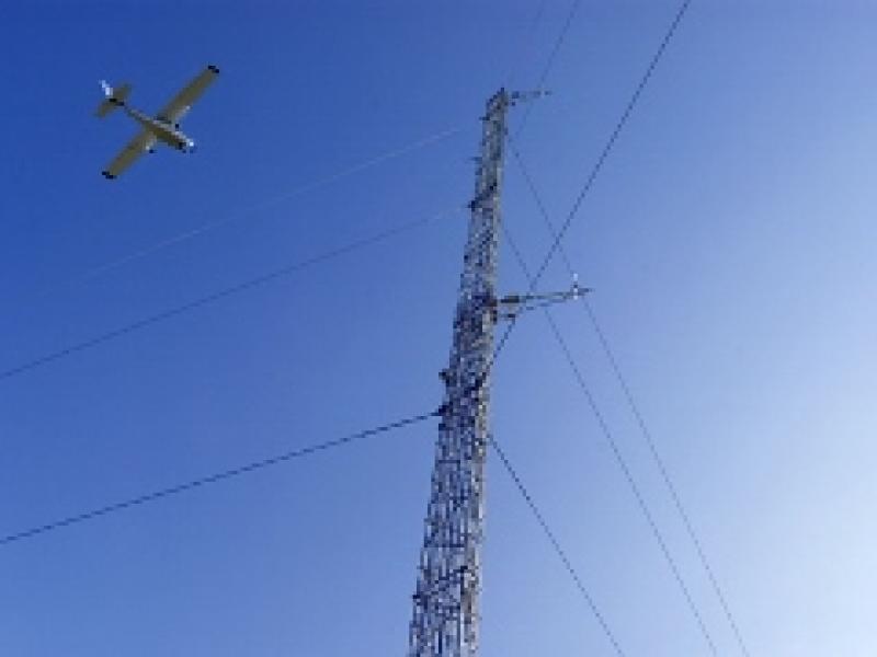 A plane flying above power lines